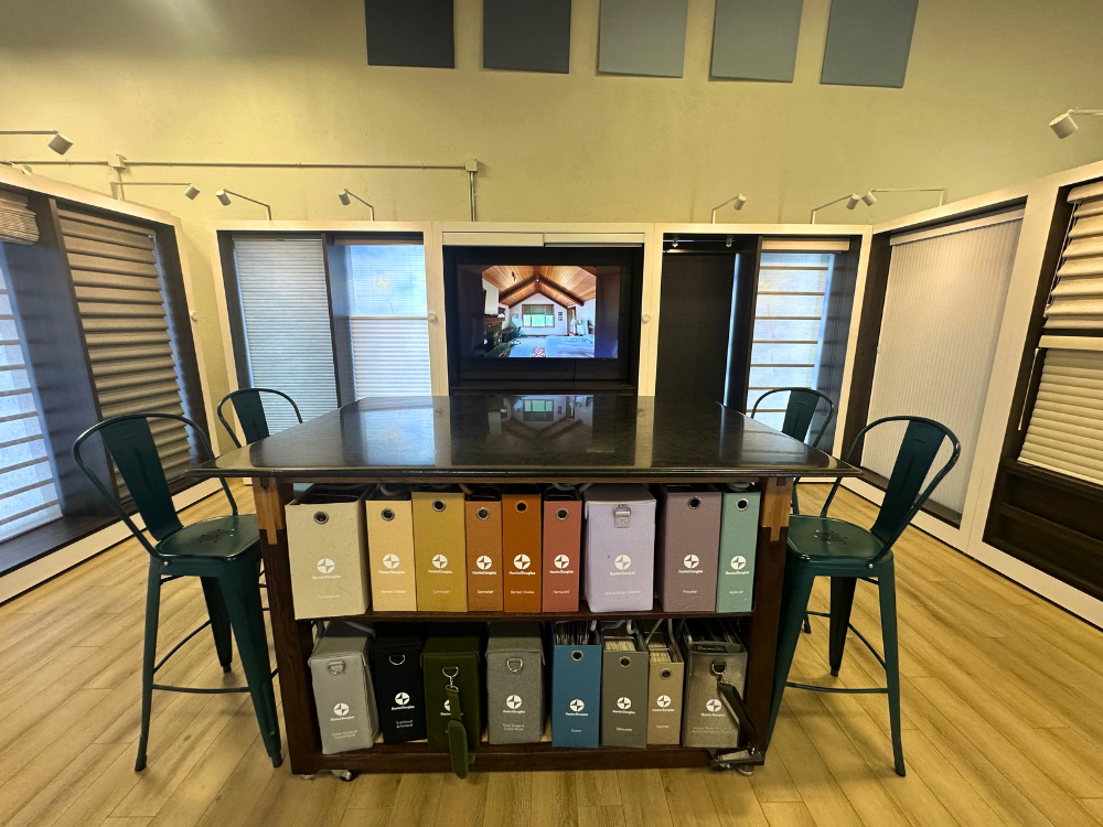 Window covering section at Grand Teton Floor & Window Coverings showroom with visualizer screen and a planning table surrounded by window cover samples.